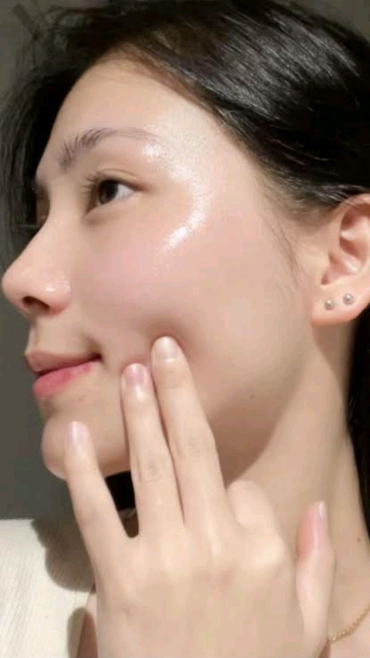 Mujer aplicando ampolla de centella de Madagascar en su rostro, mostrando piel fresca y radiante.
